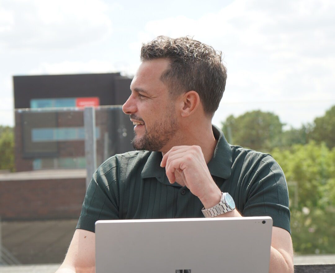 Man met laptop op dak